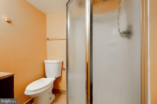 bathroom with a stall shower, baseboards, toilet, tile patterned flooring, and vanity