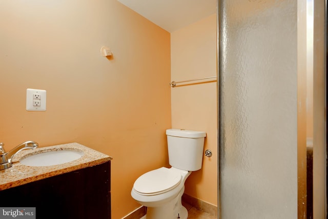 bathroom featuring baseboards, vanity, and toilet