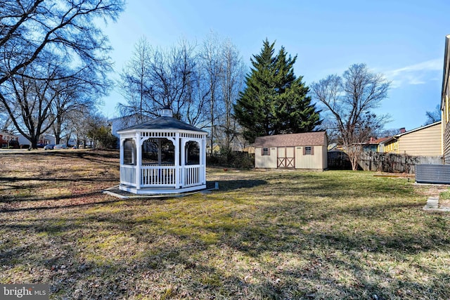 view of yard featuring an outdoor structure, fence, a gazebo, and a storage unit