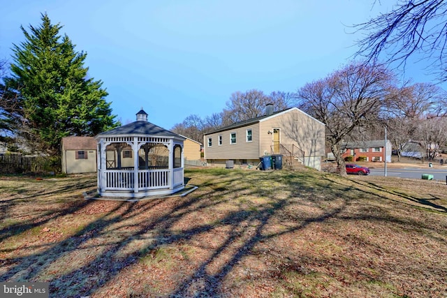 view of yard with entry steps, an outdoor structure, a gazebo, and a storage shed