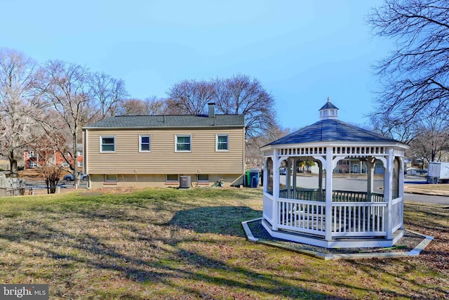 rear view of property with cooling unit, a lawn, and a gazebo