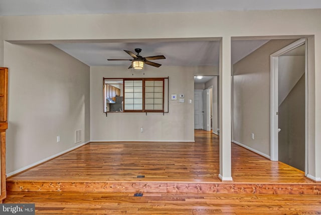 unfurnished living room with ceiling fan, wood finished floors, and visible vents