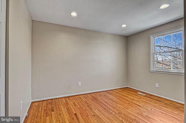 spare room with light wood finished floors, recessed lighting, visible vents, and baseboards