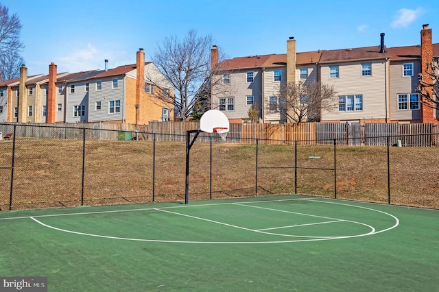 view of sport court with community basketball court, a yard, fence, and a residential view