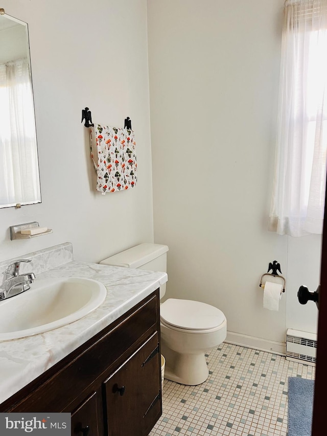 bathroom featuring tile patterned flooring, baseboards, toilet, baseboard heating, and vanity