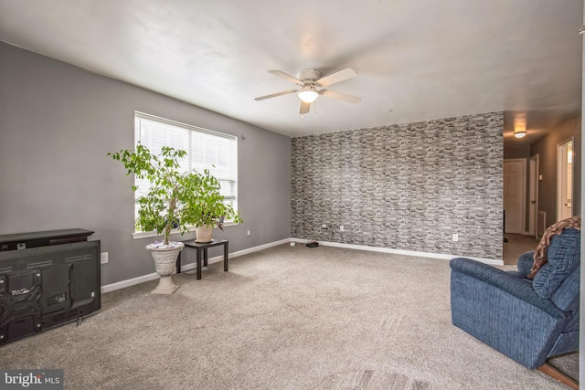 living area with ceiling fan, baseboards, and carpet flooring