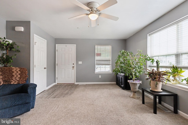 sitting room with ceiling fan, carpet, and baseboards