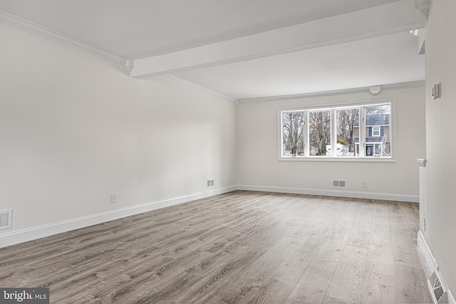 empty room featuring beam ceiling, crown molding, visible vents, wood finished floors, and baseboards