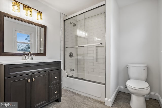 bathroom featuring baseboards, vanity, toilet, and bath / shower combo with glass door