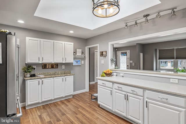 kitchen featuring light countertops, light wood-style flooring, and white cabinets