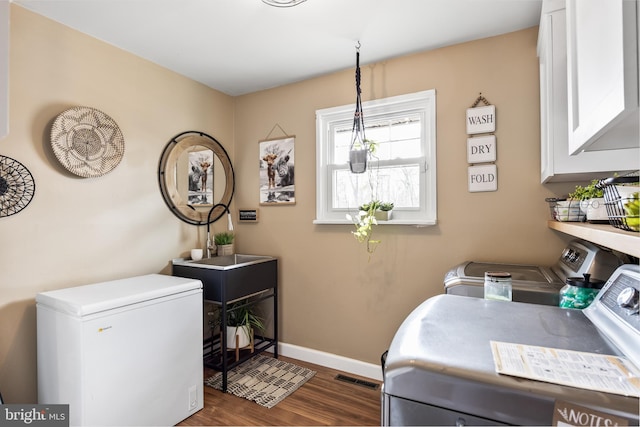 washroom with washer and clothes dryer, visible vents, cabinet space, dark wood-type flooring, and baseboards