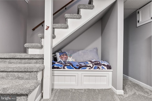 staircase featuring carpet and baseboards