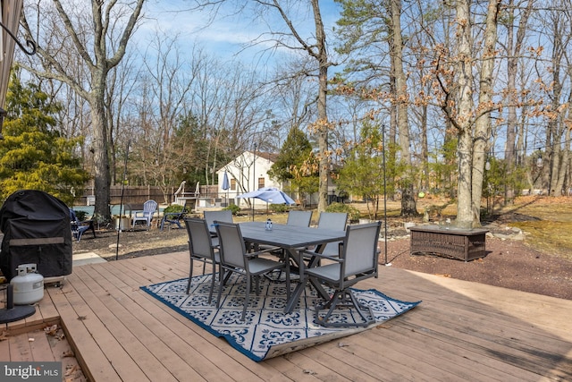 wooden deck with outdoor dining space and a grill