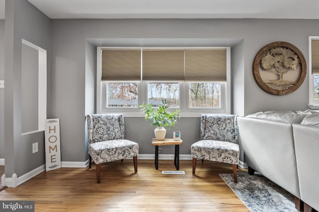 sitting room with baseboards and wood finished floors