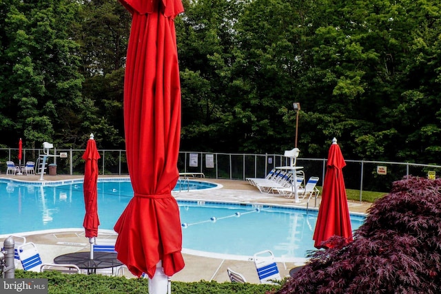 community pool with fence and a patio