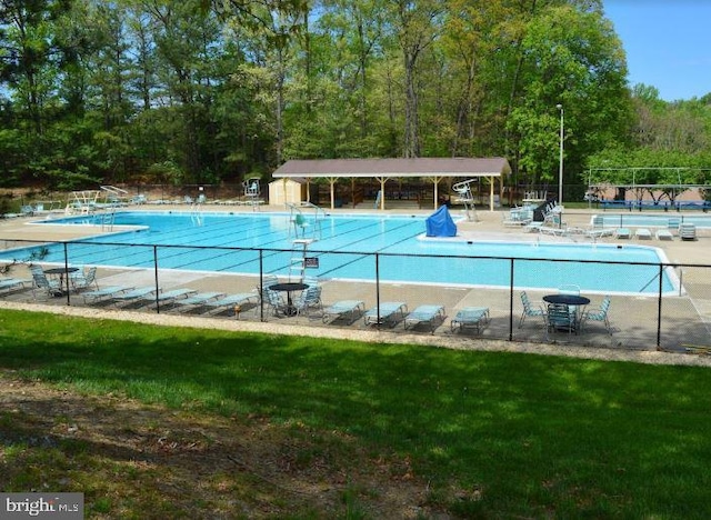 community pool featuring a yard and fence