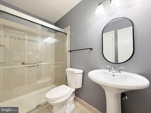 full bathroom featuring baseboards, a shower stall, toilet, and tile patterned floors