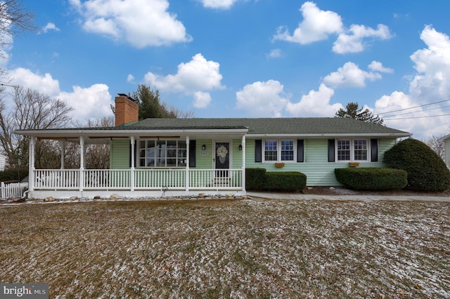 view of front of home featuring a porch and a chimney