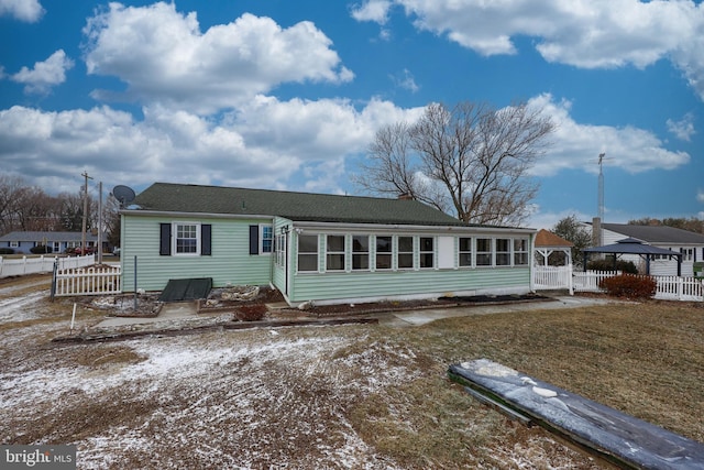 back of property featuring fence and a sunroom