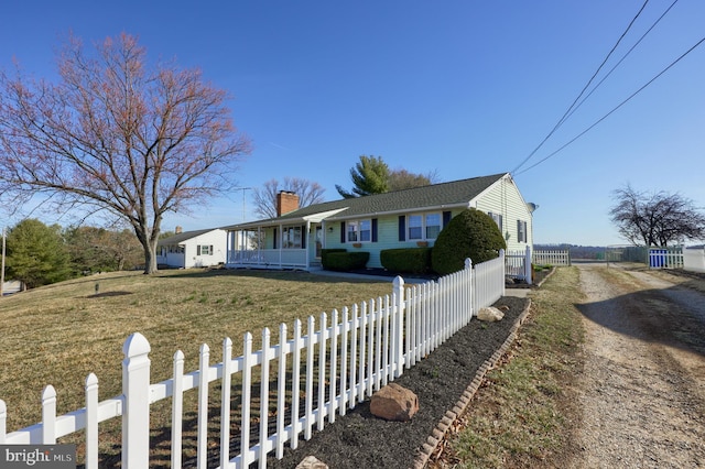 ranch-style home with a front lawn, a fenced front yard, a porch, a chimney, and driveway