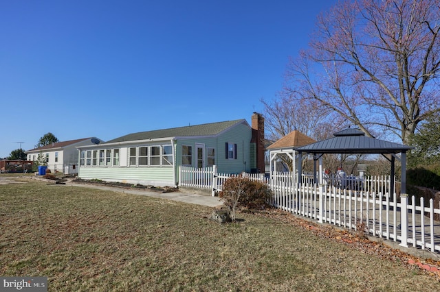 exterior space with a gazebo, a chimney, a yard, and fence