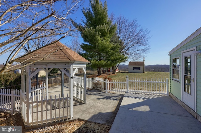 view of yard featuring fence, a gazebo, a storage shed, an outdoor structure, and a patio