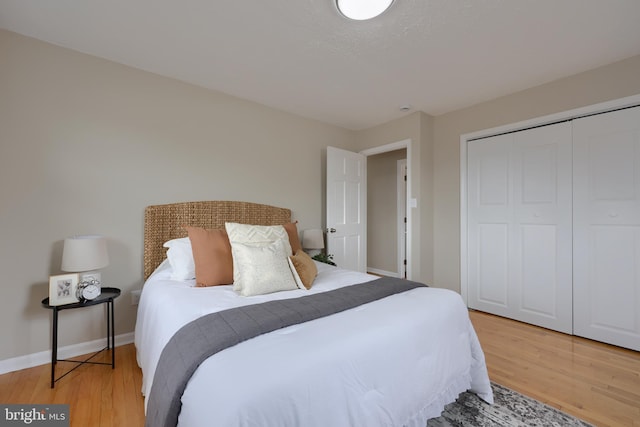 bedroom featuring a closet, baseboards, and light wood-style floors