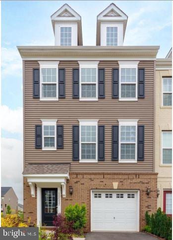 view of front of house featuring brick siding, driveway, and an attached garage