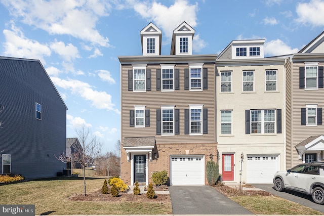 multi unit property featuring a garage, driveway, brick siding, and a front lawn