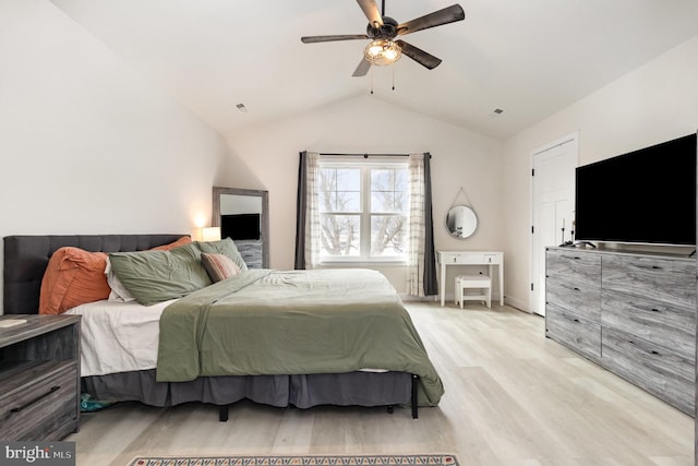 bedroom featuring light wood finished floors, ceiling fan, baseboards, and vaulted ceiling