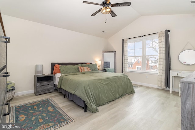 bedroom with lofted ceiling, light wood-type flooring, visible vents, and baseboards