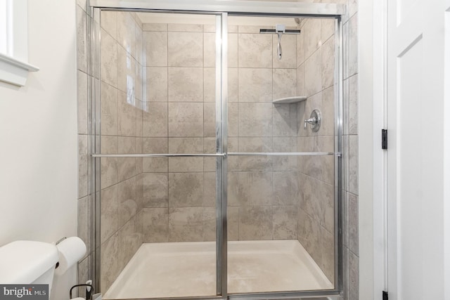 bathroom featuring a shower stall and toilet