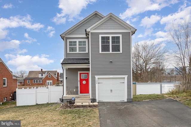 view of front of property featuring a garage, fence, and a front lawn