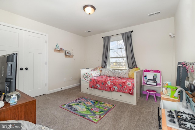 carpeted bedroom featuring baseboards, visible vents, and a closet