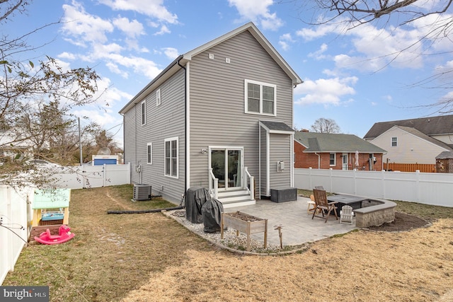 back of house with entry steps, a patio area, a yard, and a fenced backyard