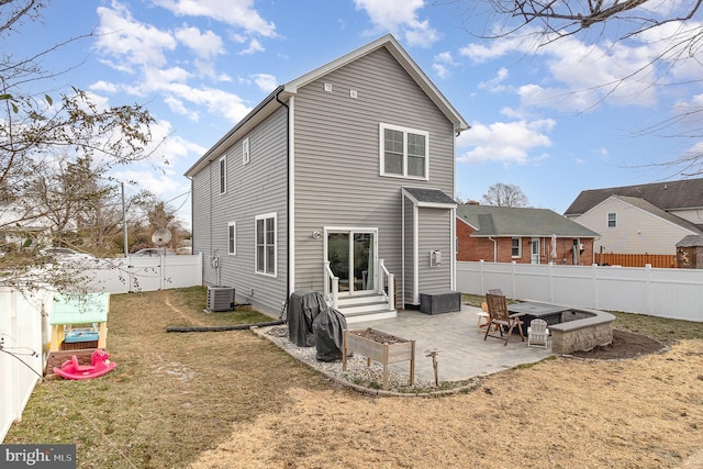 rear view of property featuring entry steps, a patio, a lawn, and a fenced backyard