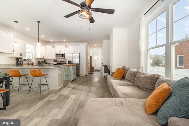 living room featuring light wood-style floors, recessed lighting, and a ceiling fan