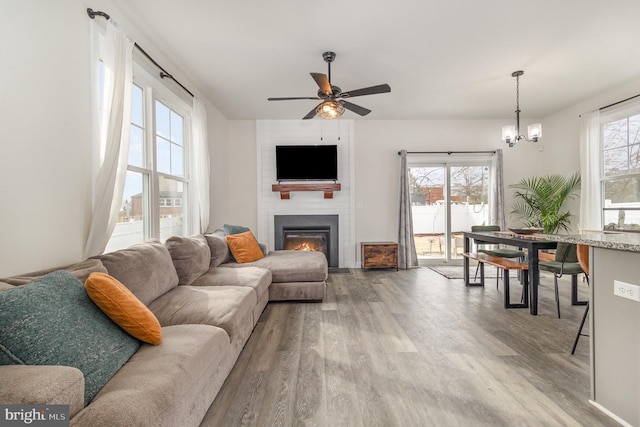 living room featuring a wealth of natural light, a large fireplace, and wood finished floors