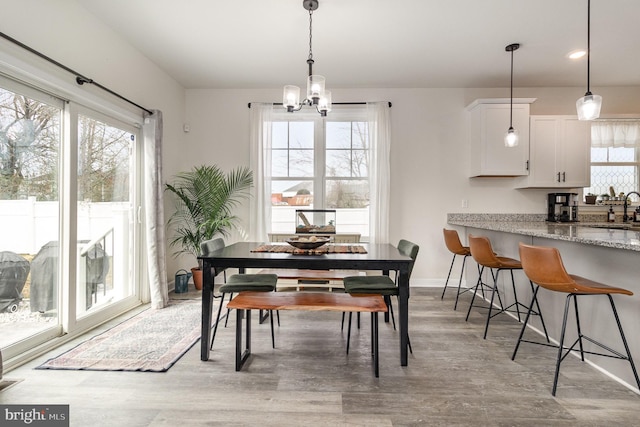 dining area with recessed lighting, an inviting chandelier, light wood-style flooring, and baseboards