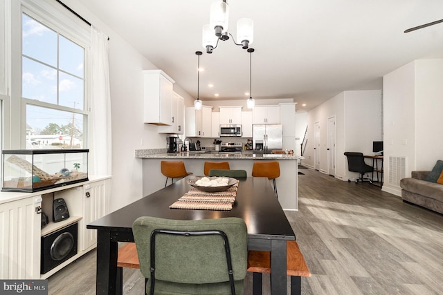 dining space featuring an inviting chandelier, light wood-style flooring, and recessed lighting