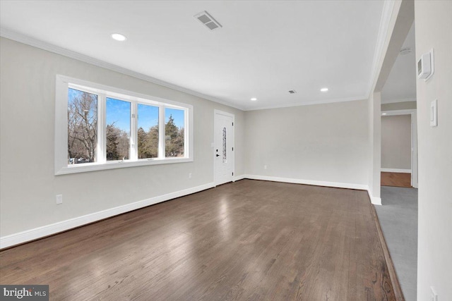 interior space featuring ornamental molding, visible vents, dark wood finished floors, and baseboards