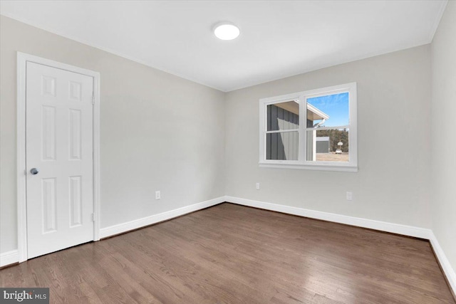 empty room with wood finished floors and baseboards