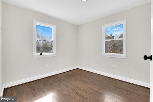 unfurnished room featuring dark wood-style floors and baseboards