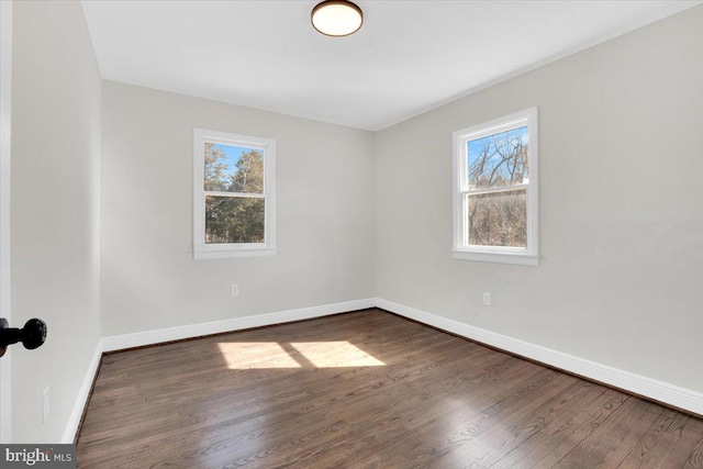 unfurnished room featuring dark wood finished floors and baseboards