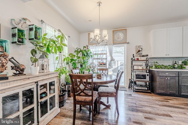 dining room featuring a chandelier, light wood-type flooring, and visible vents