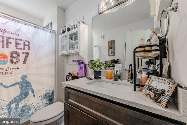 full bath featuring a shower with shower curtain, visible vents, vanity, and toilet