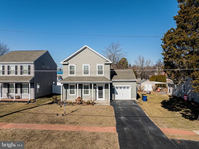 traditional home with aphalt driveway, a garage, covered porch, roof with shingles, and a front yard