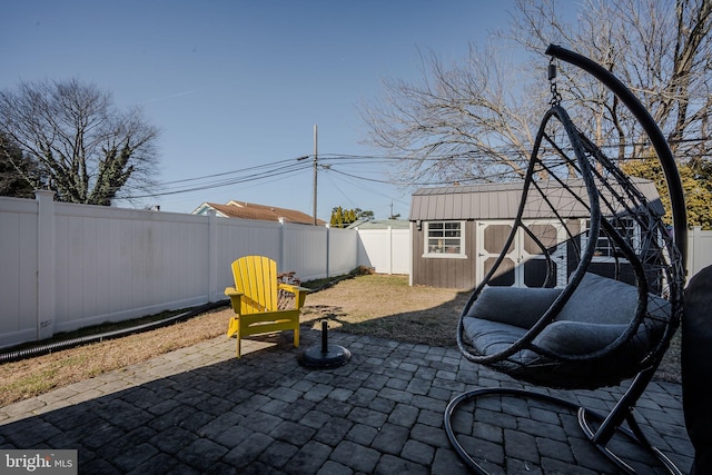 view of patio with a fenced backyard, a storage unit, and an outdoor structure