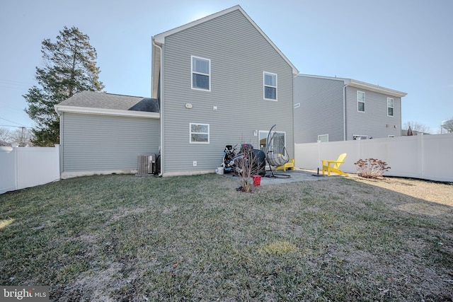 back of property with a fenced backyard, central AC unit, and a lawn