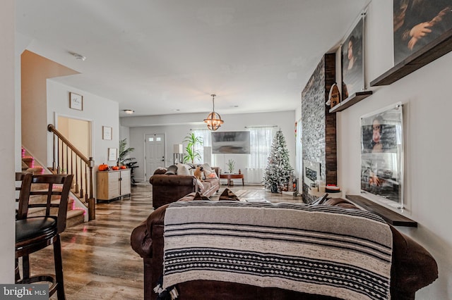 bedroom with a notable chandelier, a fireplace, and wood finished floors